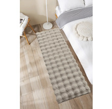 Decoratieve slaapkamer met bed, stoel en een rechthoekig vloerkleed