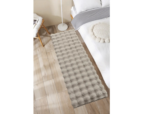 Decoratieve slaapkamer met bed, stoel en een rechthoekig vloerkleed