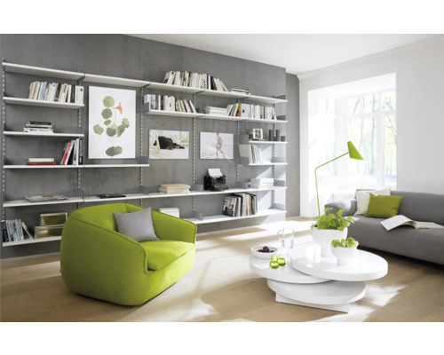 Lichte woonkamer met boekenkast, fauteuil en bank