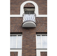 Gevel van een bakstenen gebouw met raam en balkon