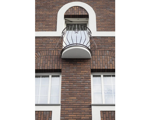 Gevel van een bakstenen gebouw met raam en balkon