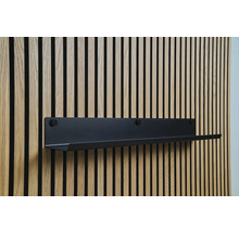 Zwarte wandplank aan houten lambrisering