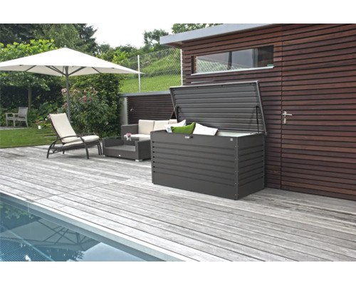 Tuinscene met zwembad, terras, parasol, loungemeubels en een open opbergbox