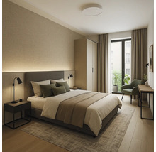 Lichte slaapkamer met tweepersoonsbed, nachtkastje, fauteuil en kledingkast voor een lichte, uitnodigende sfeer.