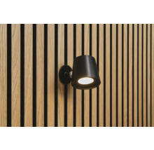 Zwarte wandlamp aan een muur met houten panelen