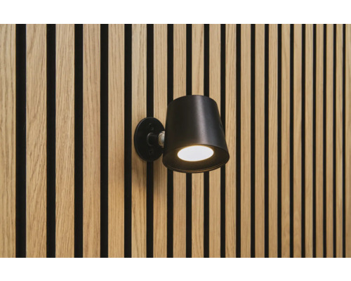 Zwarte wandlamp aan een muur met houten panelen
