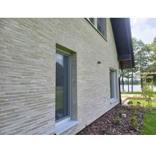 Buitenkant van een huis met bakstenen muren en ramen