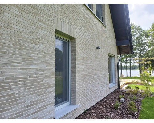 Buitenkant van een huis met bakstenen muren en ramen