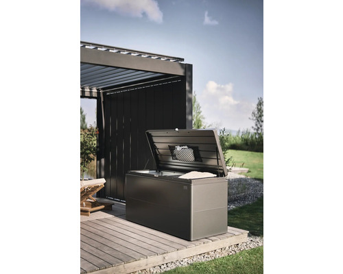 Geopende opbergbox op een houten terras in de tuin.