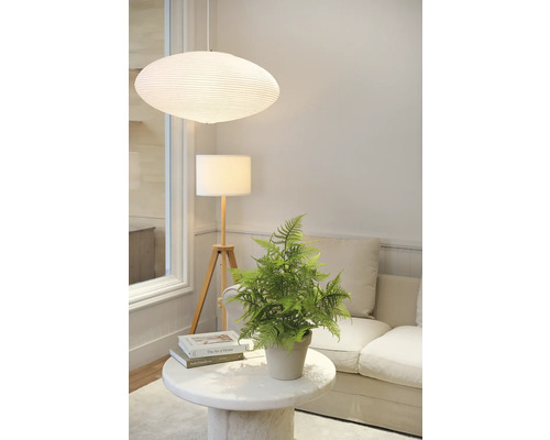 Decoratief interieur met hanglamp, staande lamp, tafel en kunstplant.