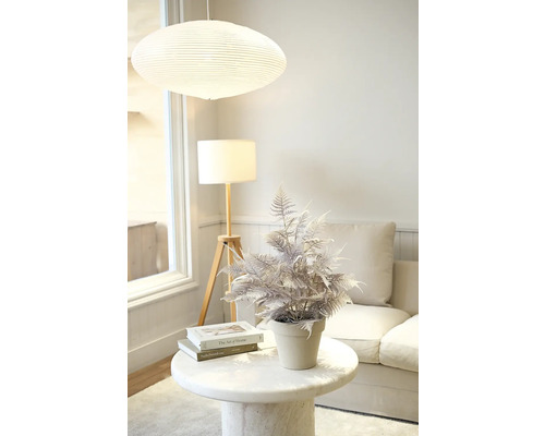 Decoratieve kunstplant op een bijzettafel in een woonkamer.