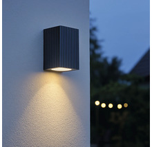 Vierkante wandlamp van metaal met verticale strepen en lichtbundel
