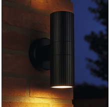 Zwarte buitenwandlamp met geribbelde lampbehuizing op een bakstenen muur