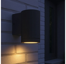 Een zwarte buitenwandlamp is gemonteerd op een bakstenen muur.