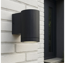 Zwarte buitenwandlamp aan een witte bakstenen muur