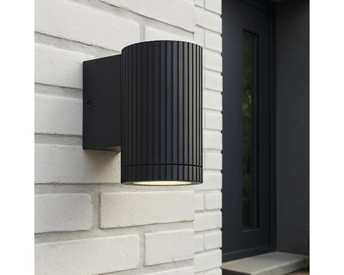 Zwarte buitenwandlamp aan een witte bakstenen muur
