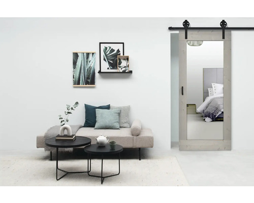 Woonkamer met daybed, salontafels en schuifdeur met spiegel