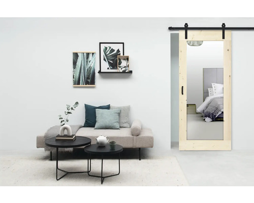 Woonkamer met bank, salontafels, wanddecoratie en schuifdeur met spiegel