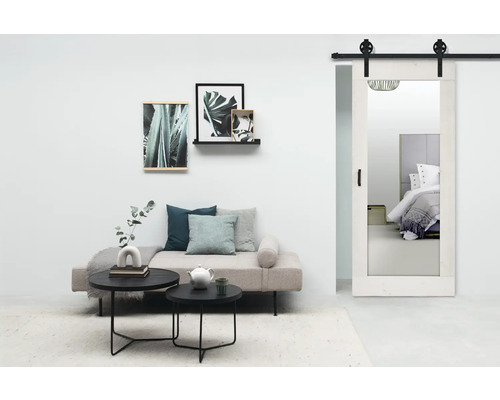 Woonkamer met bank, salontafels, wanddecoraties en schuifdeur