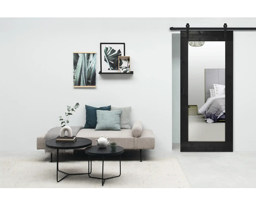 Woonkamer met bank, tafel en schuifdeur met spiegel