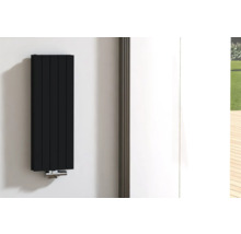 Zwarte radiator aan de muur met buisaansluiting