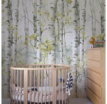 Kinderkamer met een behang met berkenmotief, een rond babybed en een commode