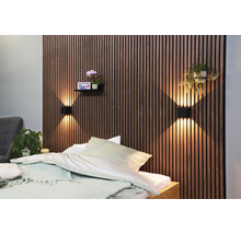 Slaapkamer met houten lambrisering, wandlampen, plank met decoratie en bed