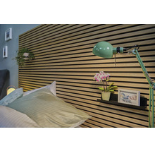 Slaapkamer met bed, wandpanelen en groene lamp