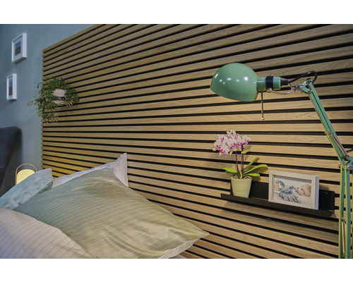 Slaapkamer met bed, wandpanelen en groene lamp