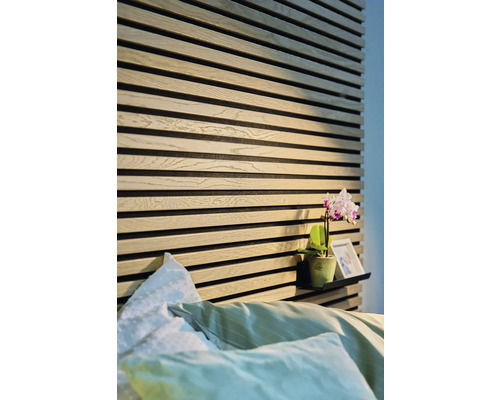 Slaapkamer met houten wandpanelen en een plank met decoratie