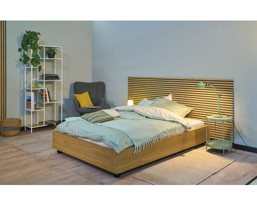 Lichte slaapkamer met houten bed, nachtkastlamp, plank en fauteuil