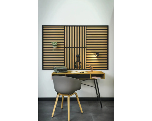 Inrichting met bureau, stoel en akoestisch paneel aan de wand.