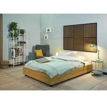 Lichte slaapkamer met bed, nachtkastje, lamp, plank en fauteuil