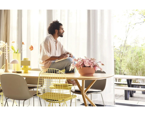 Lichte ruimte met tafel, stoelen en man met notitieboekje