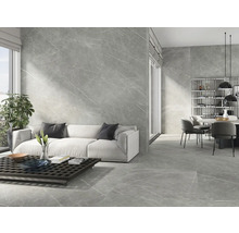 Moderne woonkamer met grijze marmeren tegels op de wand en vloer, bank en eettafel