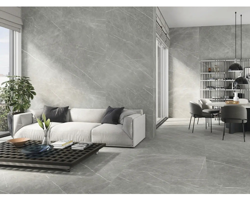 Moderne woonkamer met grijze marmeren tegels op de wand en vloer, bank en eettafel