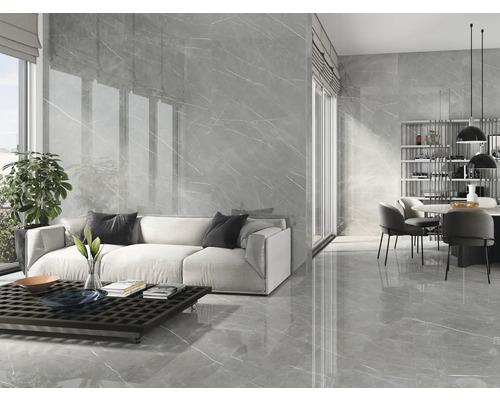 Lichte woonkamer met grijze marmeren tegels op de vloer en muur, bank, eettafel en raam