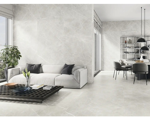 Lichte woonkamer met vloer- en wandtegels in marmerlook, bank, tafel en eethoek