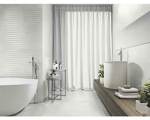 Lichte badkamer met vrijstaand bad, wastafel en gestructureerde wandtegels voor een modern design.