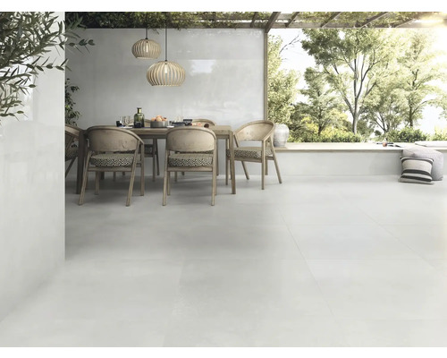 Licht terras met eettafel, stoelen en bijpassende vloertegels voor buiten.