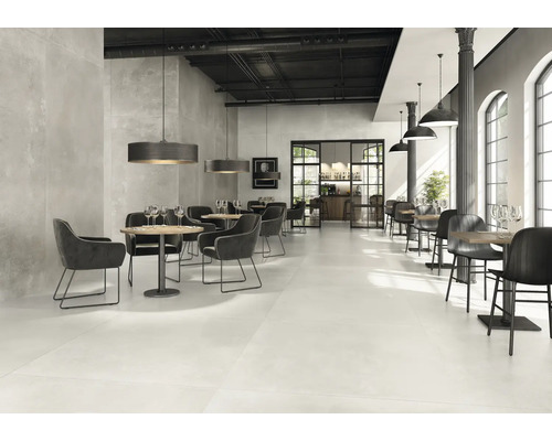 Ruim restaurant met tafels, stoelen en vloertegels.