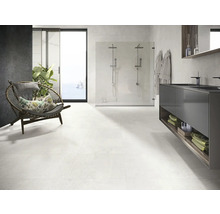 Lichte badkamer met douche, wastafel en fauteuil