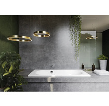 Moderne badkamer met ligbad, betonnen muur en cirkelvormige hanglampen