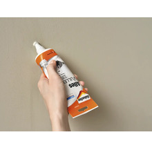 Een hand vult een gat in de muur met Allesvuller van Alabastine