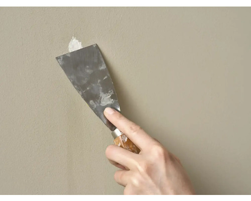 Plamuurmes wordt gebruikt om een muur te repareren