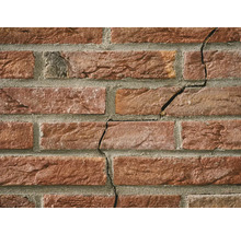 Close-up van een bakstenen muur met scheurvorming