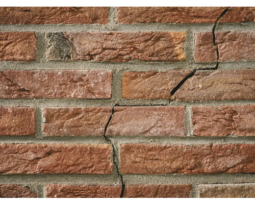 Close-up van een bakstenen muur met scheurvorming