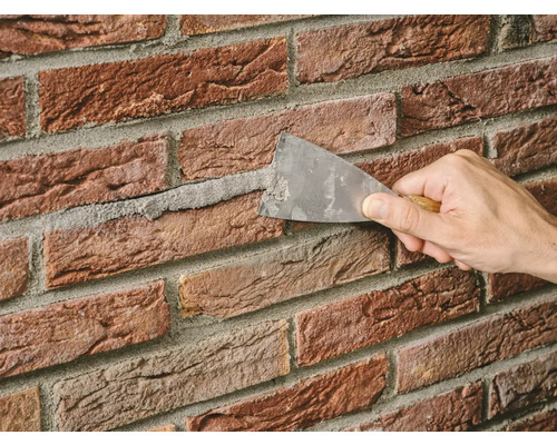 Voegen aanbrengen tussen baksteenstrips met een troffel