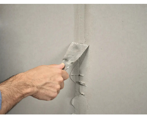 Plamuurmes wordt gebruikt om een muur glad te maken.
