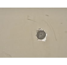 Boormachinegat met plug in een muur
